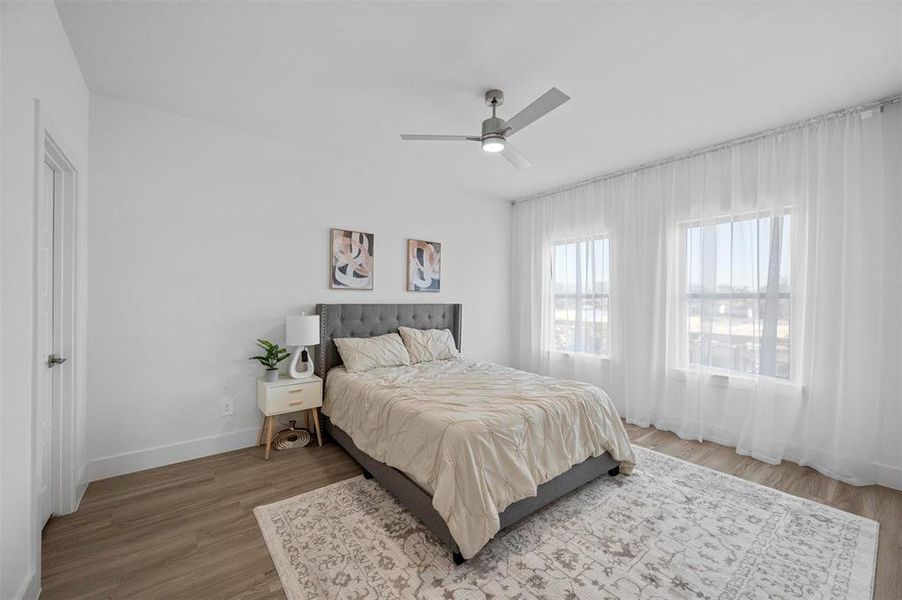 Bedroom featuring light wood-type flooring, ceiling fan, and baseboards