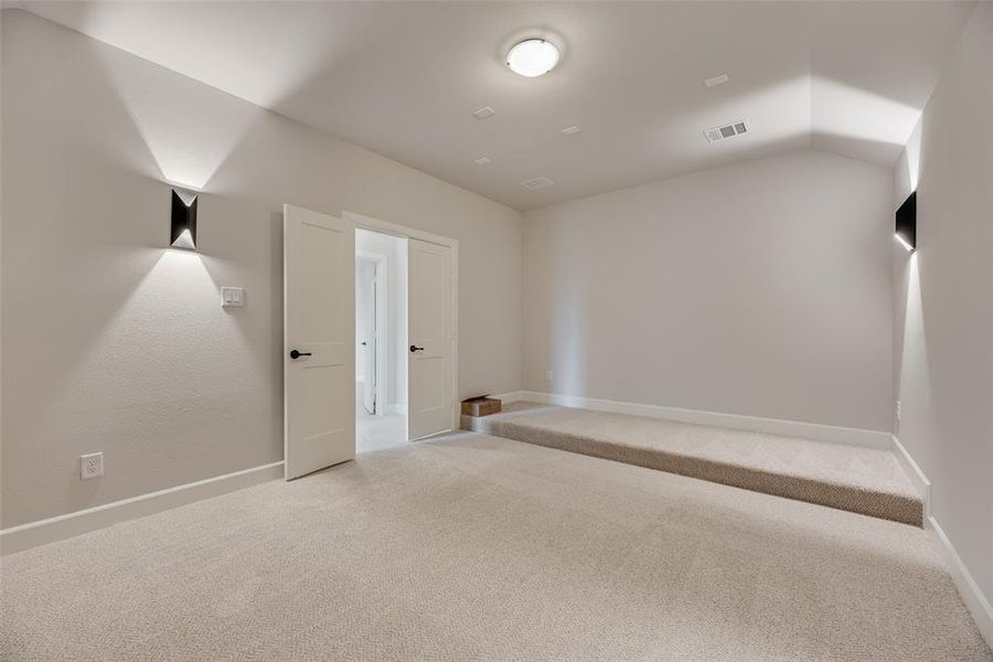 Spare room with carpet and lofted ceiling