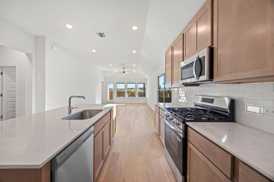 Gleaming wood flooring extends through this open-concept kitchen and living area, offering a fluid and inviting space.