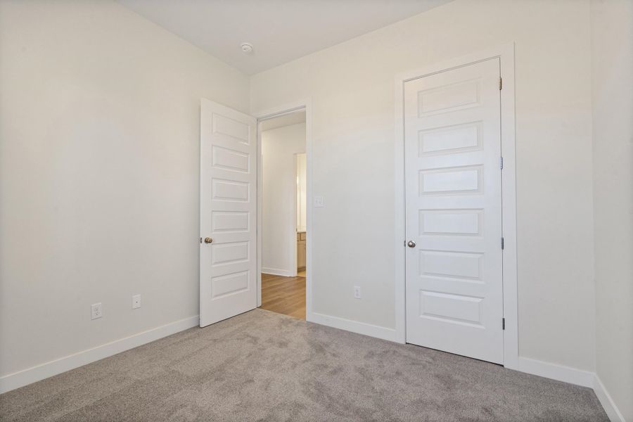 Unfurnished bedroom with light colored carpet and a closet
