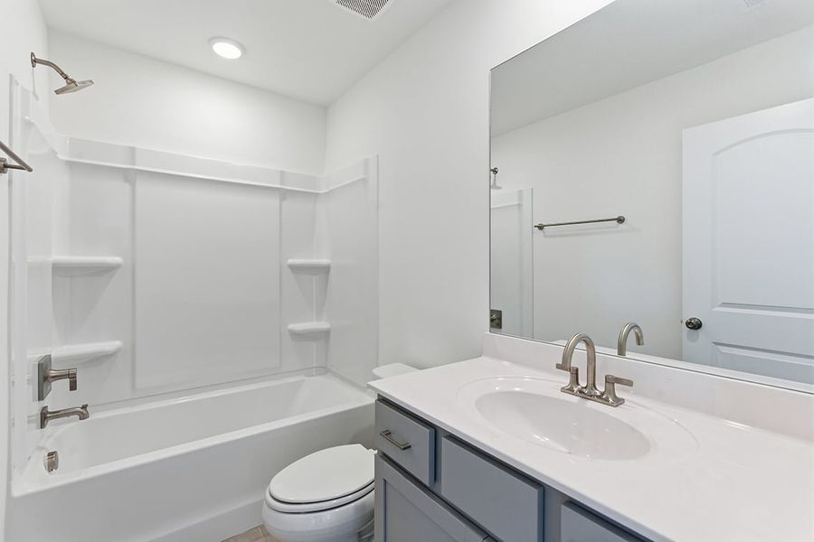 A bathroom with a tub sink and toilet.