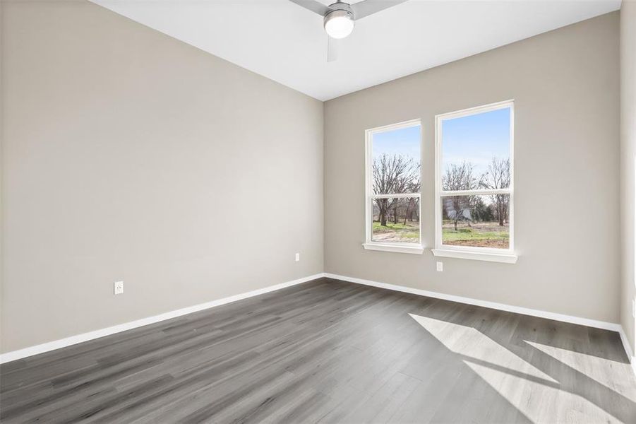 Spare room featuring dark hardwood / wood-style flooring and ceiling fan