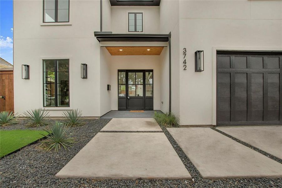 View of exterior entry featuring stucco siding and a garage View of exterior entry featuring stucco siding and a garage