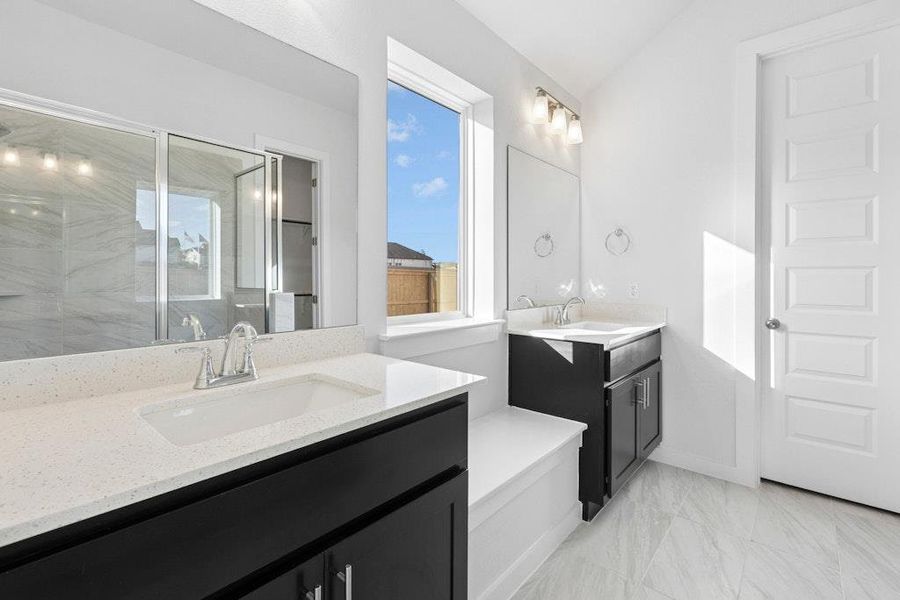 Full bath with a marble finish shower, two vanities, and light marble finish flooring