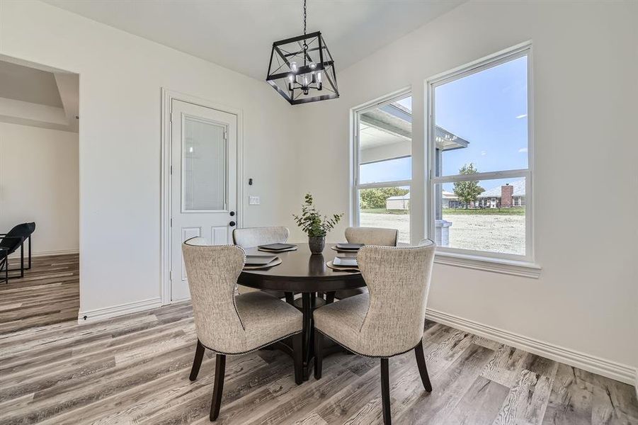 Dining area featuring an inviting chandelier and hardwood / wood-style flooring