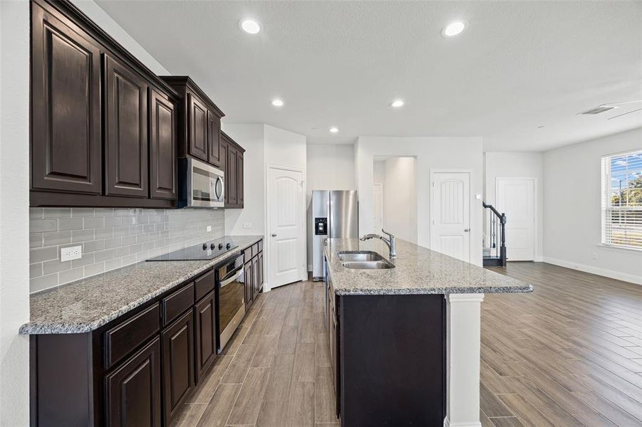 Large kitchen with granite counters and stainless appliances.