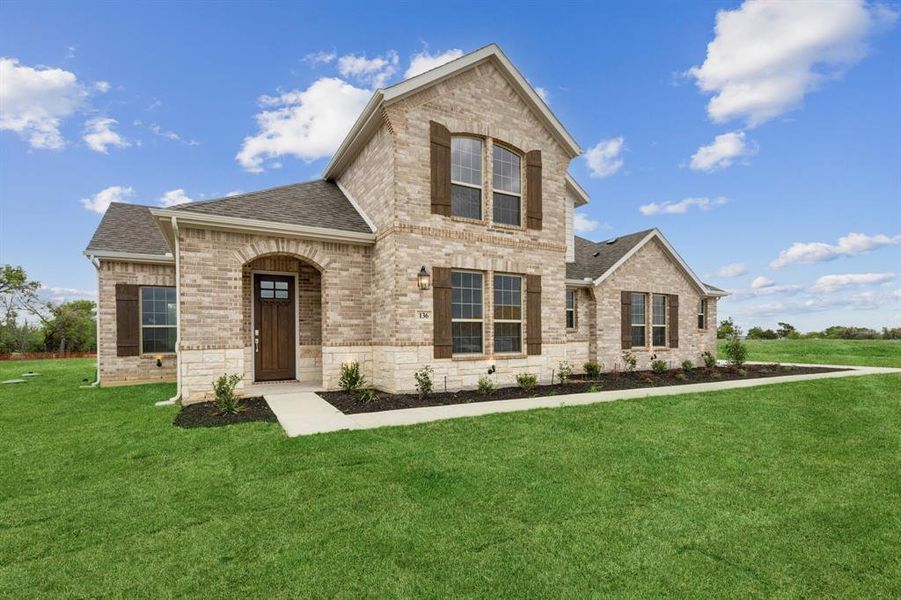 View of front of house featuring a shingled roof, brick siding, and a front lawn View of front of house featuring a shingled roof, brick siding, and a front lawn