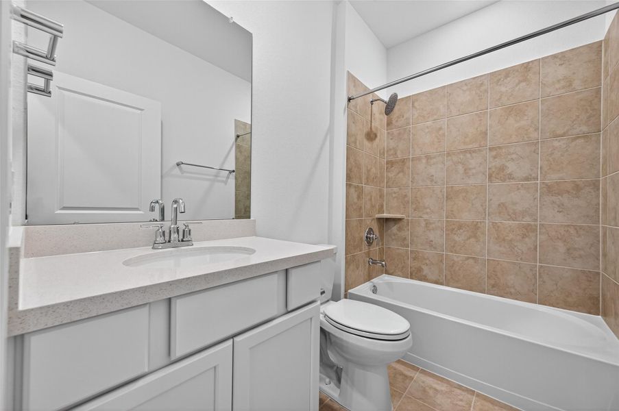 This full bathroom features a sleek vanity with ample storage, a large mirror, and a beautifully tiled tub-shower combo for both comfort and style. This full bathroom features a sleek vanity with ample storage, a large mirror, and a beautifully tiled tub-shower combo for both comfort and style.
