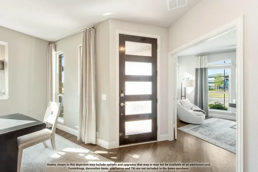 Entryway with dark front door featuring glass panels, hardwood floors, and view into living room
