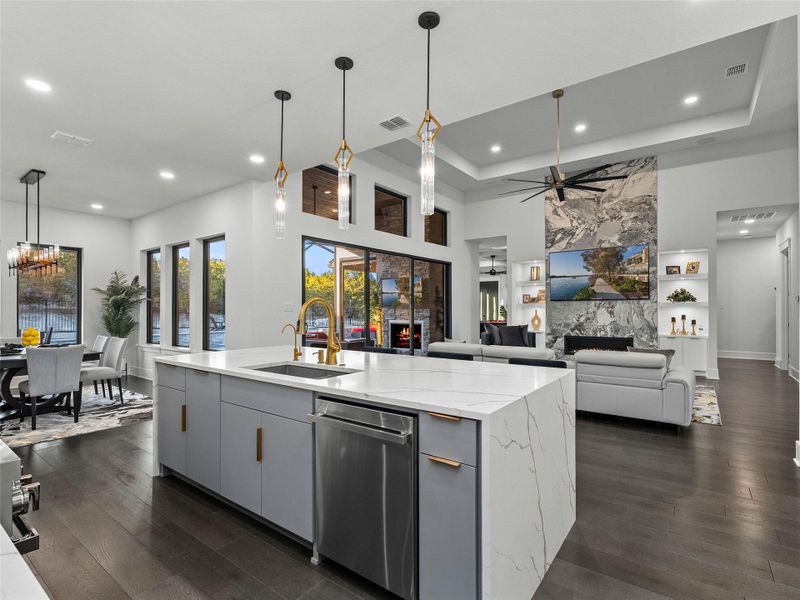 Kitchen with open floor plan, an island with sink, dark wood finished floors, and stainless steel dishwasher