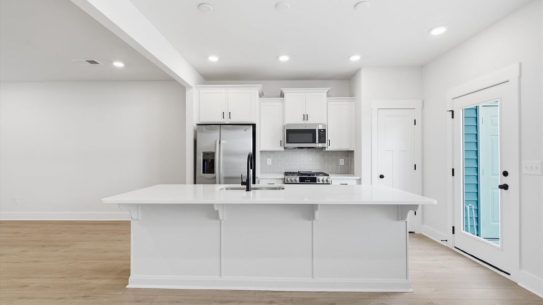 Tasteful kitchen with a streamlined island and modern finishes in a first-class DRB Homes design Tasteful kitchen with a streamlined island and modern finishes in a first-class DRB Homes design
