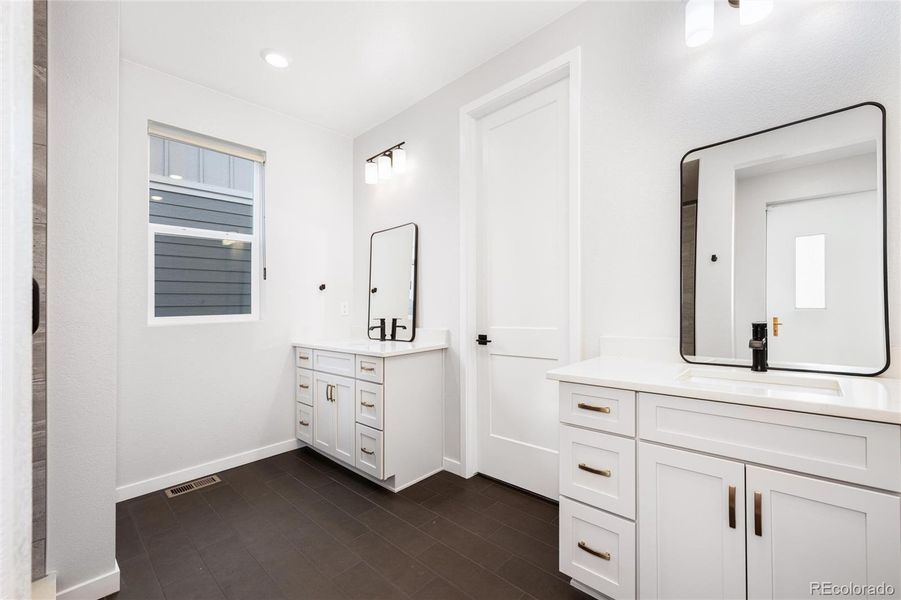 Ensuite bathroom with dual vanities, large shower and walk-in closet.