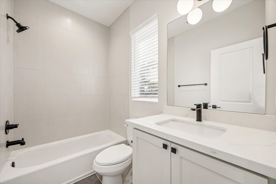 Ensuite bath with quartz counters and a shower/tub combo.