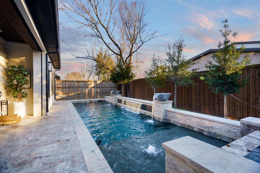 Pool at dusk with pool water feature