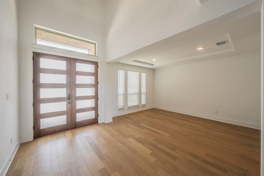 Entryway featuring hardwood floors, a transom window above the front doors, and recessed lighting