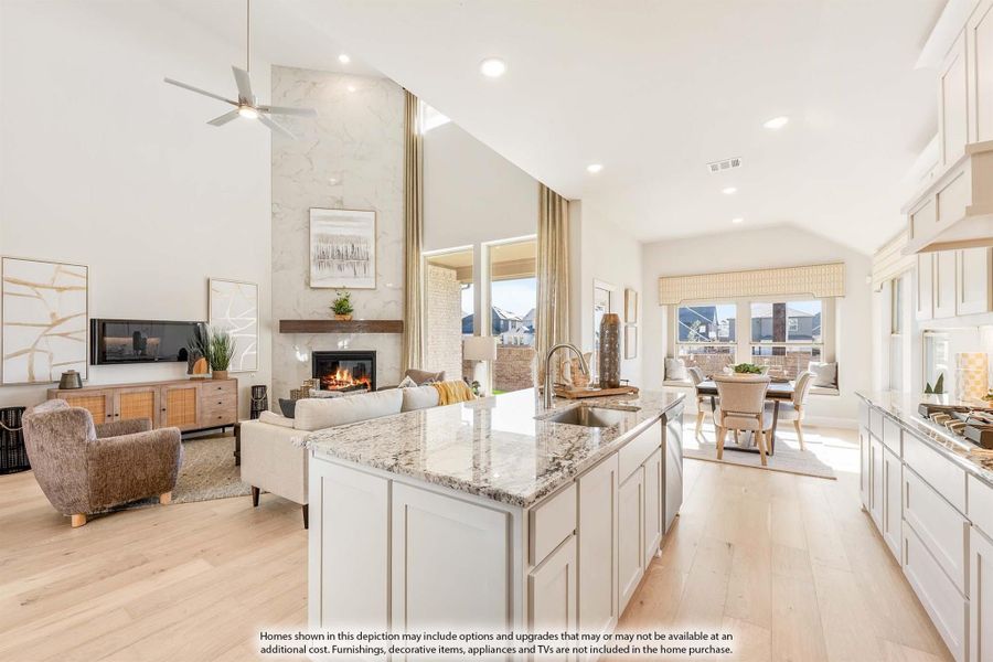 Open-concept kitchen and living area with granite island, vaulted ceiling, stone fireplace, and light hardwood floors Open-concept kitchen and living area with granite island, vaulted ceiling, stone fireplace, and light hardwood floors