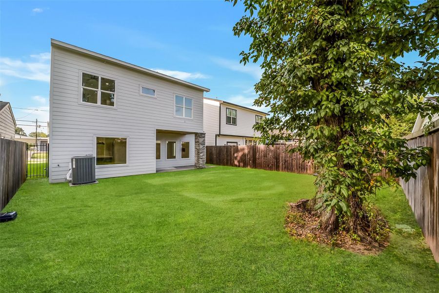 Spacious fenced backyard with covered patio, offering plenty of room for outdoor living and entertaining.