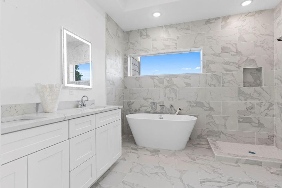 Elegant primary bathroom with soaking tub, walk-in shower, and premium finishes.