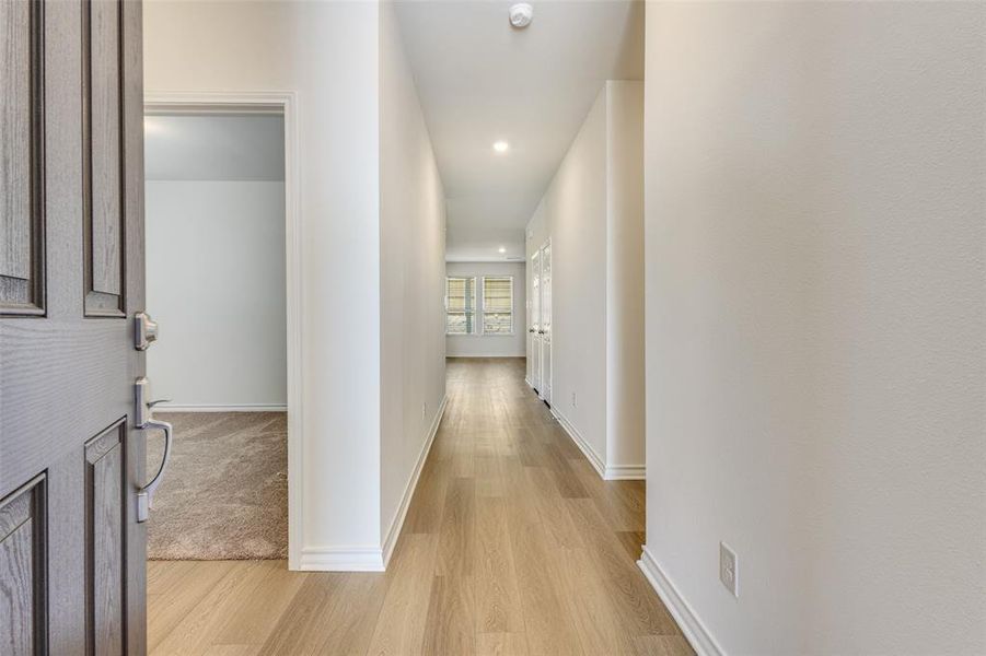 Hall featuring light wood-style flooring and recessed lighting Hall featuring light wood-style flooring and recessed lighting