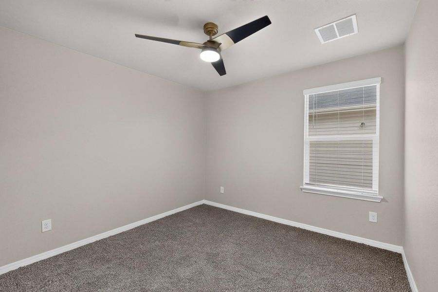 Plush carpeting and natural light define this versatile bedroom space.