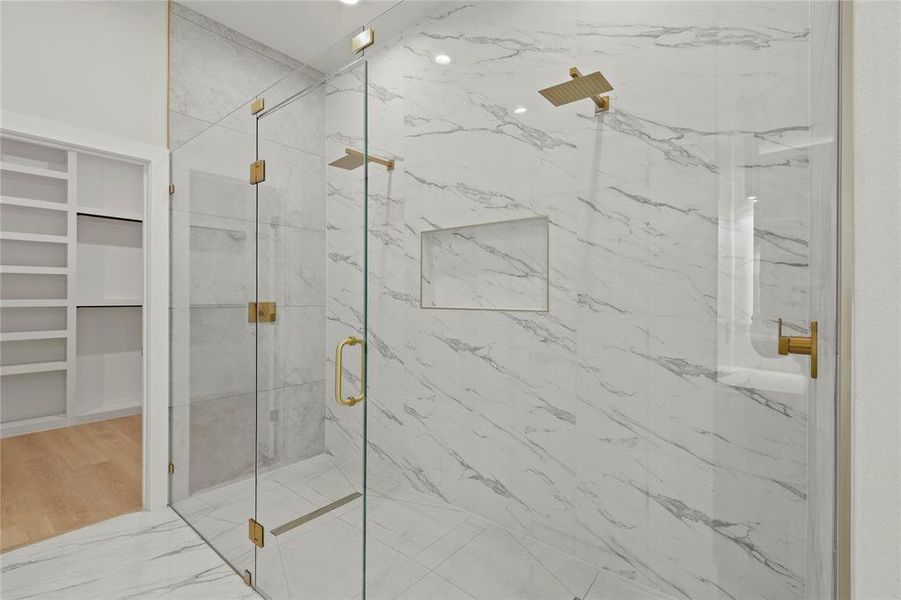 Bathroom with a marble finish shower and wood finished floors