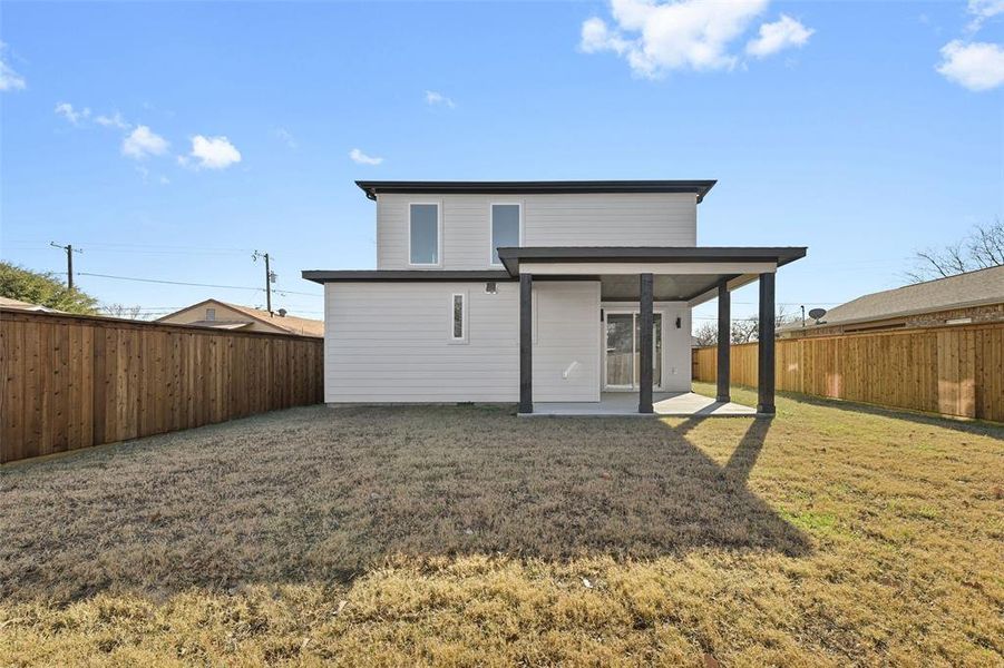 Back of house with a patio area and a yard