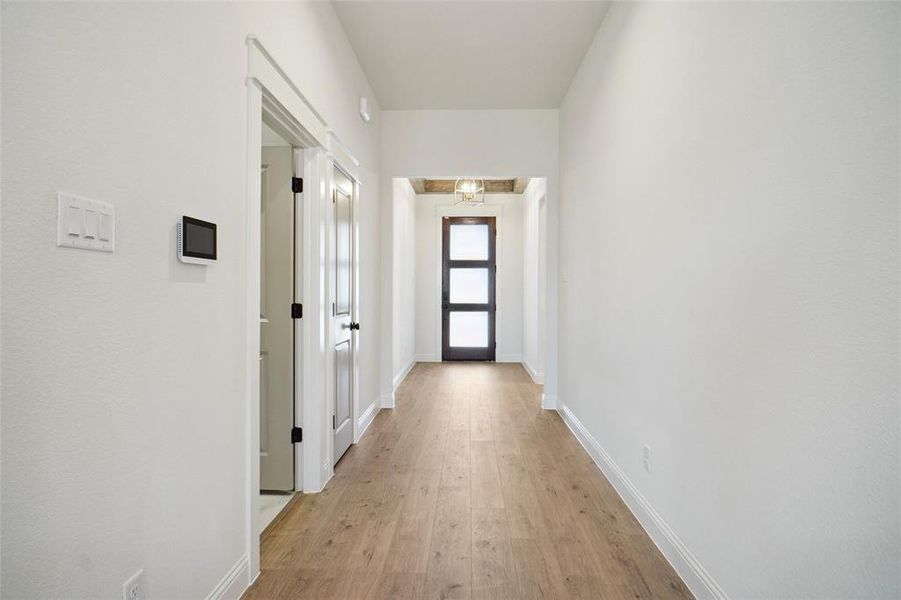 Corridor with a chandelier and light hardwood / wood-style floors