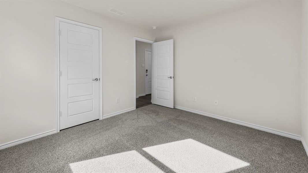 Spacious room featuring light gray carpeting and white painted walls