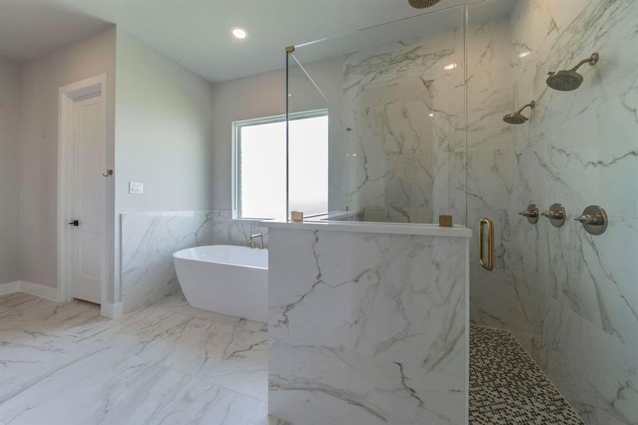 Full bath with a marble finish shower, a freestanding bath, tile walls, a wainscoted wall, and marble finish floors Full bath with a marble finish shower, a freestanding bath, tile walls, a wainscoted wall, and marble finish floors