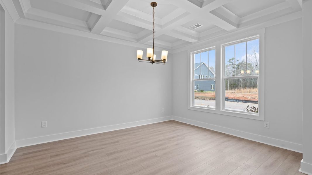 Tasteful coffered ceiling highlights the high standards of this vibrant DRB Homes dining room