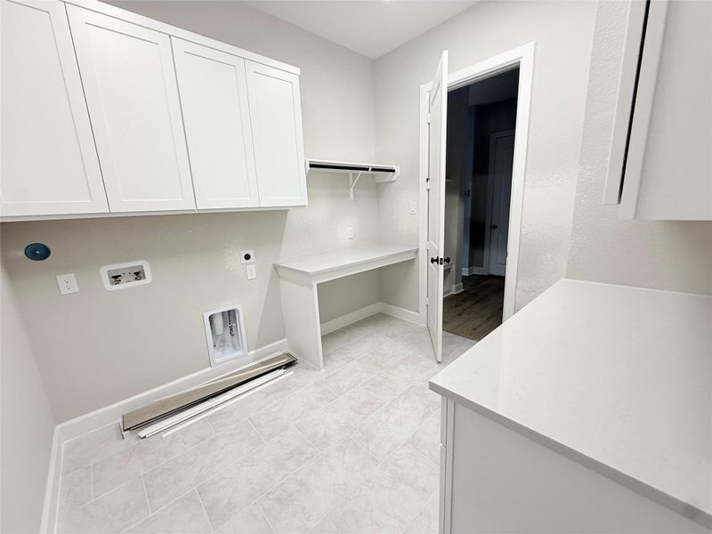 Oversized laundry area with built in cabinets, folding table & more!