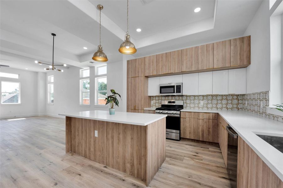 The beautifully appointed kitchen has quartz countertops, lots of cabinets for storage, and a large island for easy cooking and entertaining during dinner parties and get togethers.