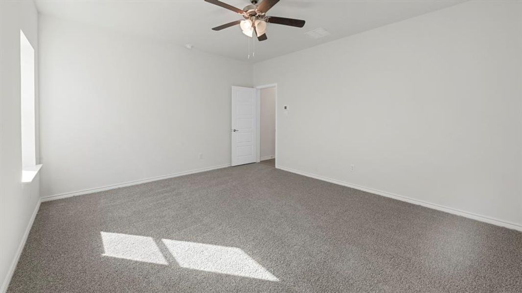 Spacious room featuring neutral carpeting, light-toned wall paint, and a ceiling fan with integrated lighting Spacious room featuring neutral carpeting, light-toned wall paint, and a ceiling fan with integrated lighting