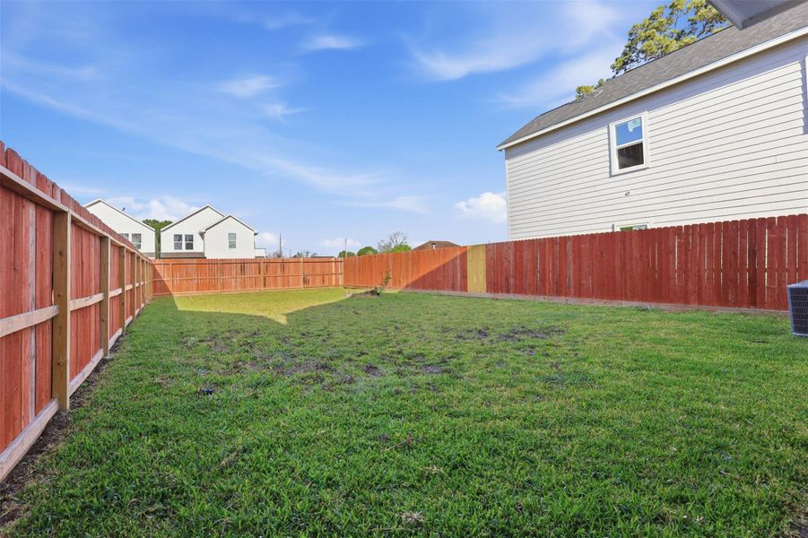 Spacious fenced backyard offering privacy and ample room for outdoor activities.