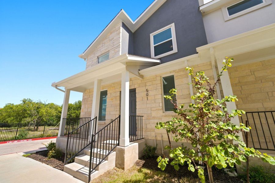 Limestone and stucco siding define the exterior facade under clear blue skies.