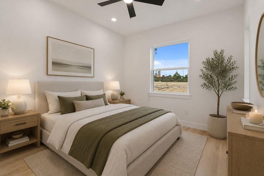 Bright secondary bedroom featuring crisp modern finishes, warm wood flooring and abundant natural light
