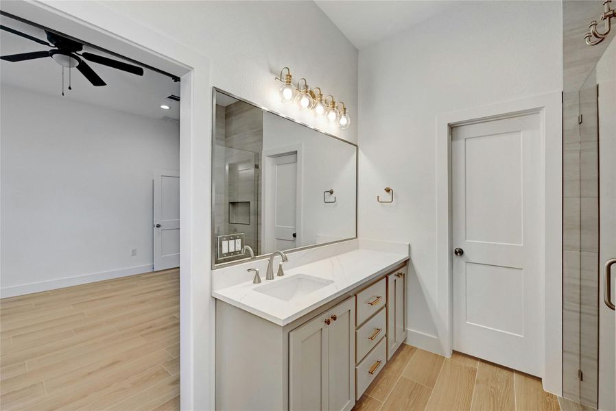 Double vanity sinks with large mirrors and gorgeous lighting fixtures.