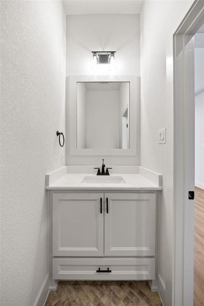 Bathroom with a textured wall and vanity