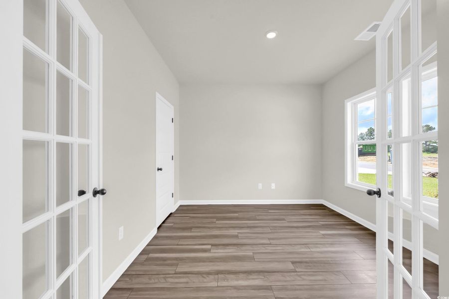 Spare room with light wood-style flooring, french doors, and recessed lighting