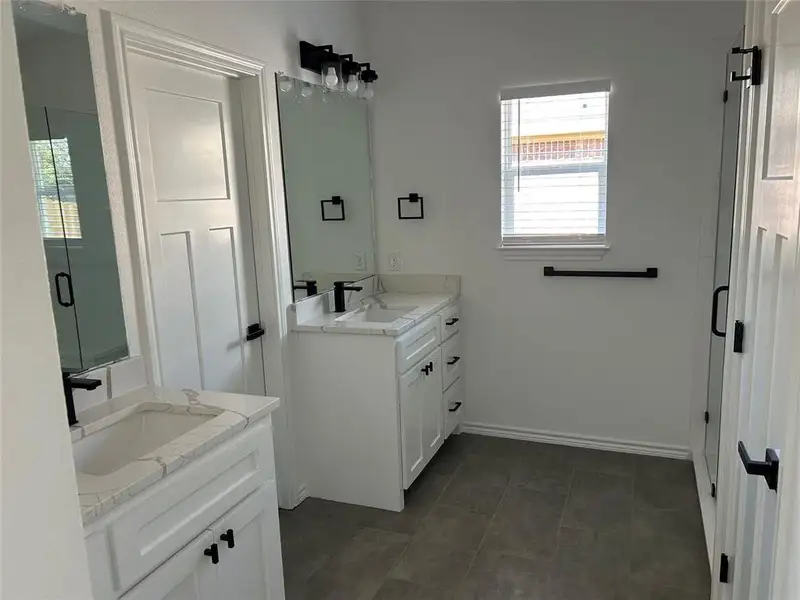 Bathroom with two vanities and a shower stall