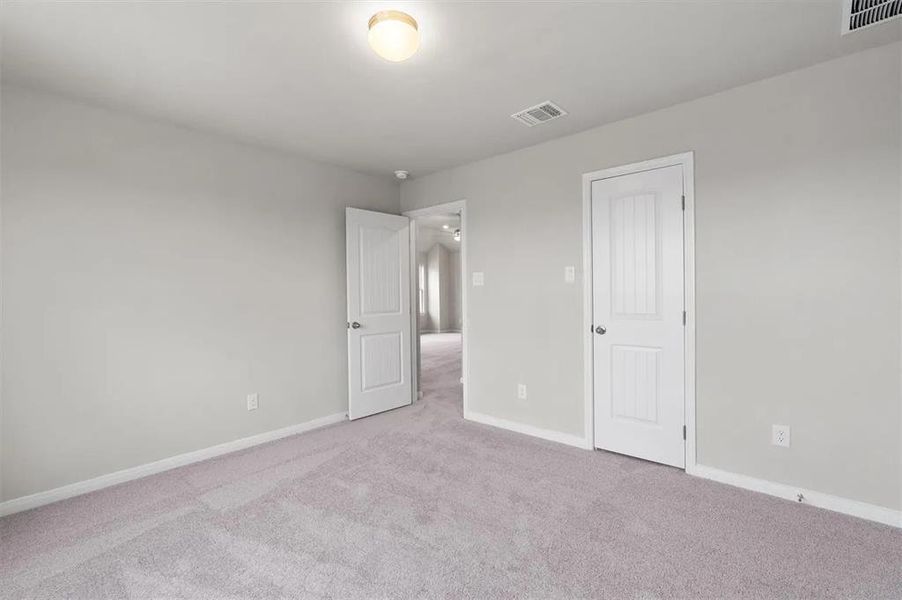 A spacious, naturally illuminated room features plush carpet and inviting neutral wall tones.