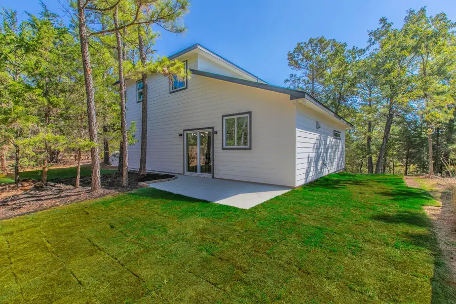 Back of house with a yard and a patio