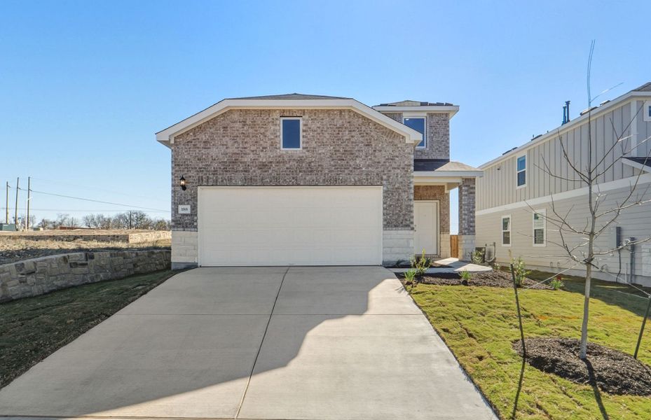 Front exterior of a new home in Sunfield, Buda, TX, highlighting curb appeal (Image 21). Front exterior of a new home in Sunfield, Buda, TX, highlighting curb appeal (Image 21).