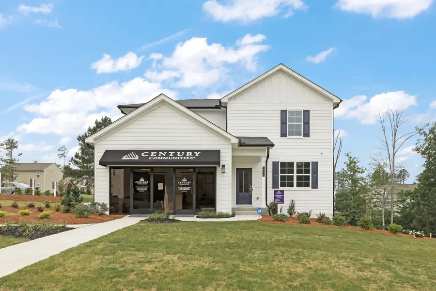 A white building with a sign on it with Southfork Ranch in the background. A white building with a sign on it with Southfork Ranch in the background.