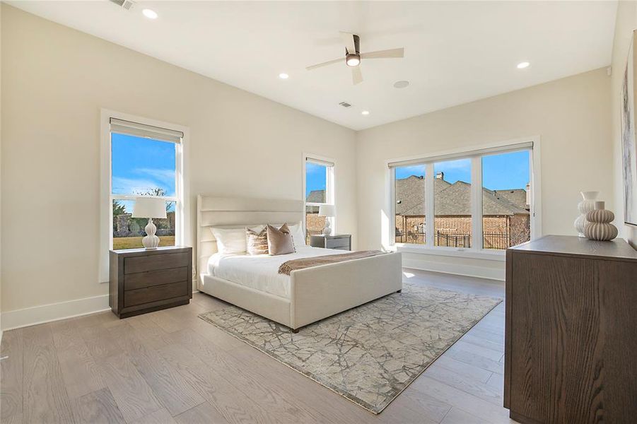 Bedroom featuring light wood-type flooring, a ceiling fan, and recessed lighting Bedroom featuring light wood-type flooring, a ceiling fan, and recessed lighting
