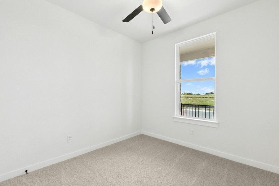 Carpeted spare room featuring baseboards and a ceiling fan