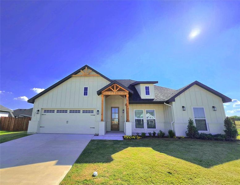 View of front of house with board and batten siding, concrete driveway, and a shingled roof View of front of house with board and batten siding, concrete driveway, and a shingled roof