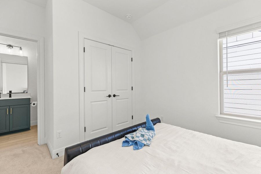 Bedroom featuring light colored carpet, a closet, and lofted ceiling