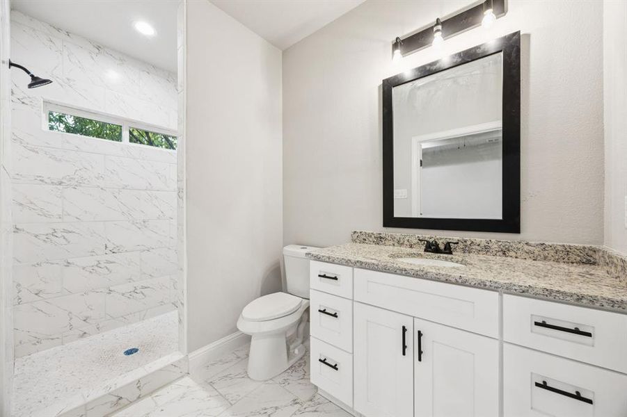 (Bedroom #1) Master Bathroom with granite countertop vanity, a marble finish shower, light marble finish floors, and recessed lighting