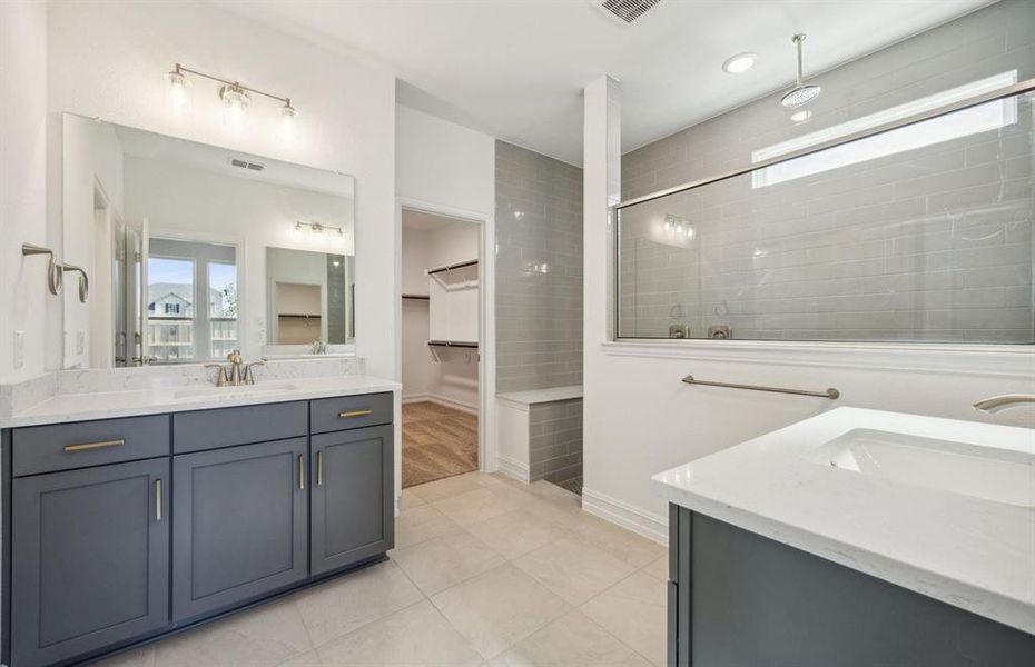 Elegant owner's suite with oversized shower *real home pictured